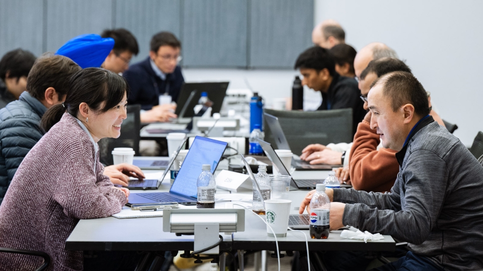 Image of researchers on laptops working at the hackathon.