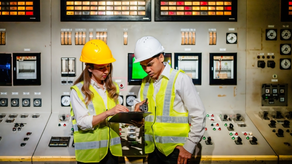 Engineers collaborate in a nuclear power plant, while machines and mechanisms operate in the control room.
